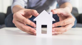 businessmen hold house model in hand